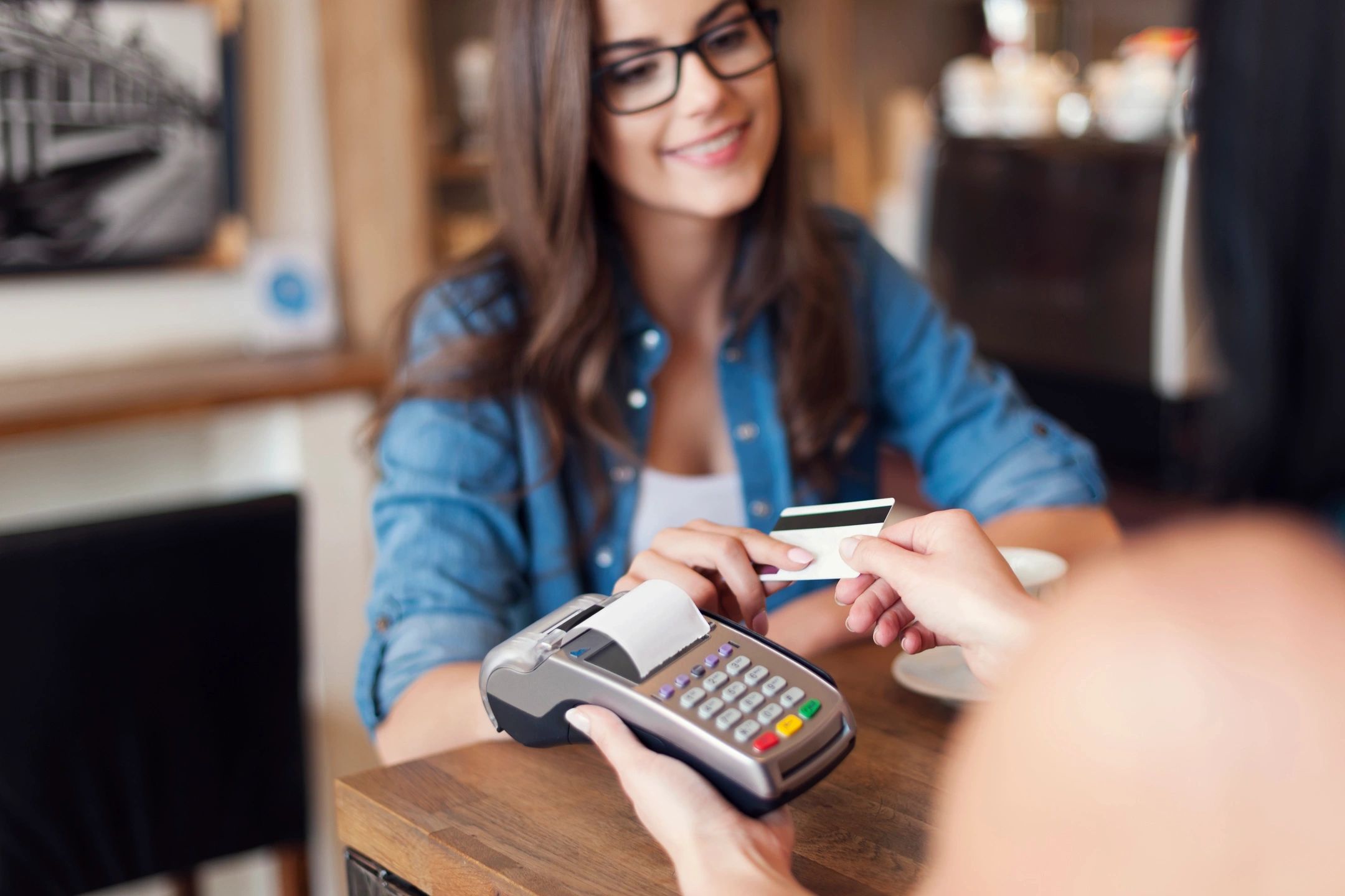 Woman making a payment with credit card at a terminal.